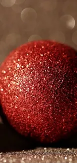 Red glitter ornament with bokeh background.