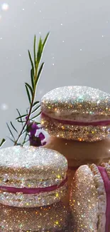 Glittery macarons with floral accents on mobile wallpaper.