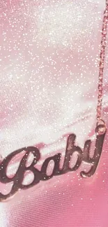 Pink glitter wallpaper with 'Baby' necklace charm.