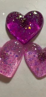 Three glittery purple hearts on a light background.