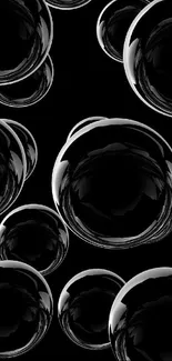 Glossy black bubbles on a dark background creating a modern, sleek wallpaper design.