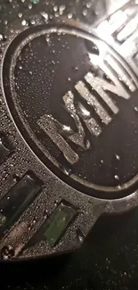 Mini car emblem with water droplets on a metallic surface.