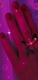 A hand with a butterfly ring on a glowing pink background with flowers.