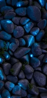 Glowing blue stones on a dark background with sprinkles of green moss.