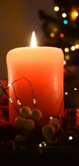 Glowing red candle with Christmas lights in a cozy setting.