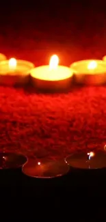 Mobile wallpaper with candles on a red background creating a warm, calming glow.