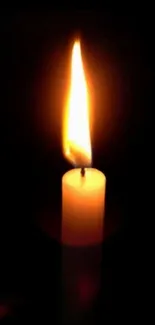 A glowing candle flame against a dark background, creating a peaceful ambiance.