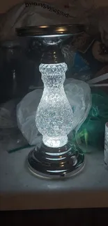 Glowing crystal lamp on cluttered surface.