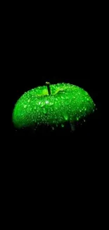 Glowing green apple with water droplets on a dark background.