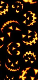 Glowing jack-o'-lantern faces on dark Halloween wallpaper.