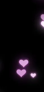 Mobile wallpaper with glowing pink hearts on black background.