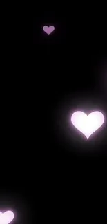 Glowing pink hearts on a black mobile wallpaper background.