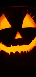 Glowing Jack-O'-Lantern with a spooky smile in dark background.