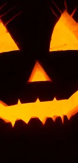 Glowing orange Jack-o'-Lantern with a spooky expression on a dark background.