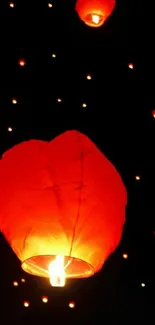 Red paper lanterns glowing against a dark night sky.