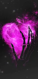 Neon pink skeleton hand forming a heart on a black background.