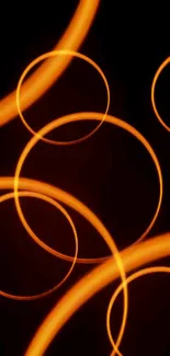 Abstract glowing orange rings on black background wallpaper.