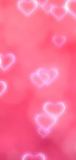 Mobile wallpaper of glowing pink hearts on a soft background.