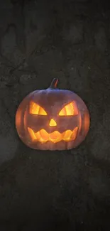 A glowing jack-o'-lantern on a dark Halloween-themed wallpaper.