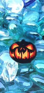 Glowing pumpkin amid blue glass pebbles, abstract wallpaper.