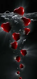 Glowing red hearts submerged in water with a dark background.