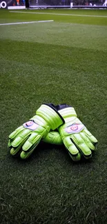 Bright green goalkeeper gloves on grass field.