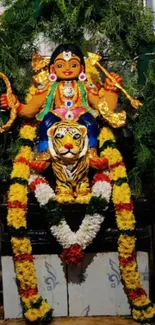 Hindu goddess statue with a tiger and vibrant floral garlands.