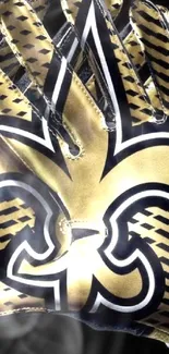 Gold and black gloves with fleur-de-lis symbol on black background.