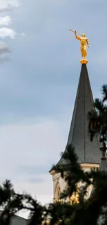 Golden angel statue on a spire against a cloudy sky.