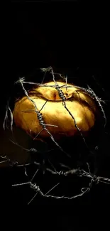 Golden apple wrapped in barbed wire on a dark background.