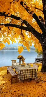 Autumn leaves canopy over lakeside picnic table.