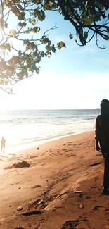 Woman walking on a golden beach at sunset.