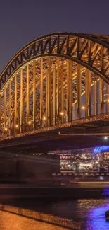 Golden bridge glows in the evening light over calm urban waters.