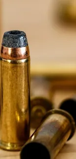 Close-up of golden bullet casings on a mobile wallpaper background.