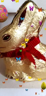 Golden bunny with red ribbon and colorful butterflies.