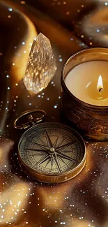 A vintage compass and glowing candle on shimmering golden fabric.