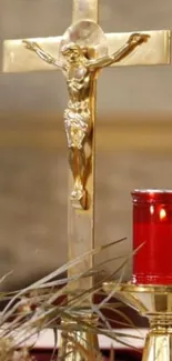 Golden cross with red candle in a spiritual setting.