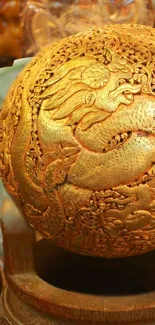 Golden dragon sphere with intricate designs on a decorative surface.