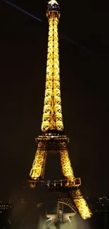 Golden Eiffel Tower glowing at night against dark sky.