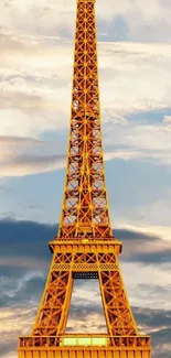 Eiffel Tower glowing golden at sunset set against a dramatic sky.