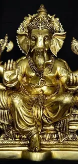 Golden Ganesha statue on black background wallpaper.