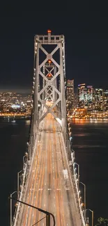 Golden Gate Bridge illuminated at night with city lights.