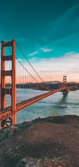 Golden Gate Bridge under a vibrant sunset sky over water.