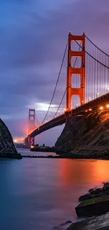 Golden Gate Bridge at sunset with vivid colors over calm waters.