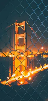 Golden Gate Bridge at night with orange glow and fence pattern.