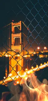 Golden Gate Bridge at night through a fence, illuminated beautifully.