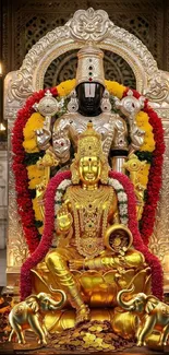 Golden Hindu deity statue with colorful garlands.