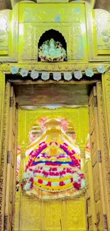 Golden doorway of a Hindu temple with vibrant floral decor.