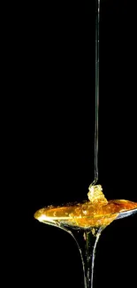 Golden honey dripping from a spoon against a black background.