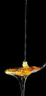 Golden honey drips from a spoon with a sleek black background.